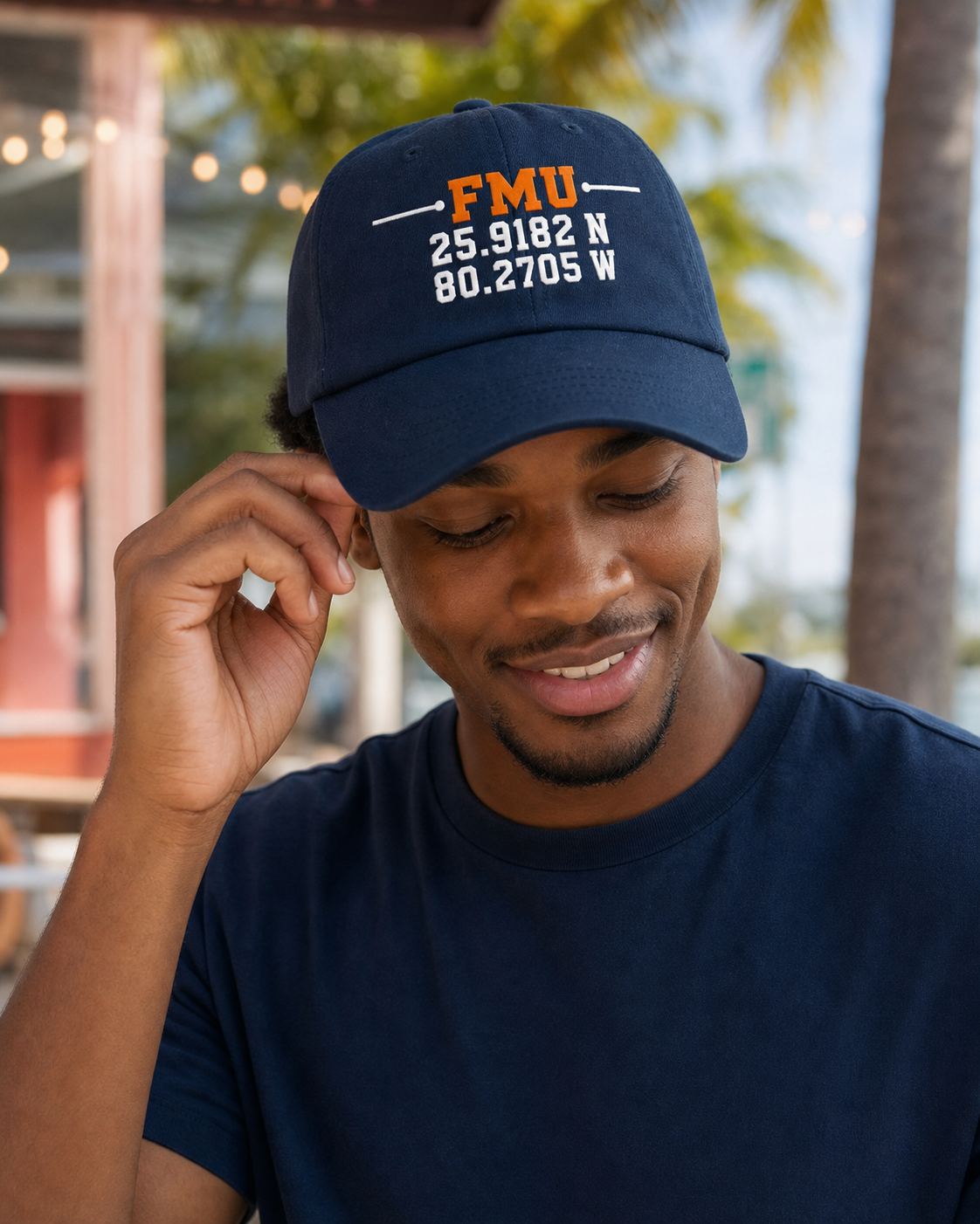 Florida Memorial University Coordinates dad hat lifestyle image, orange-and-white embroidered coordinate mark in a Miami Gardens setting.
