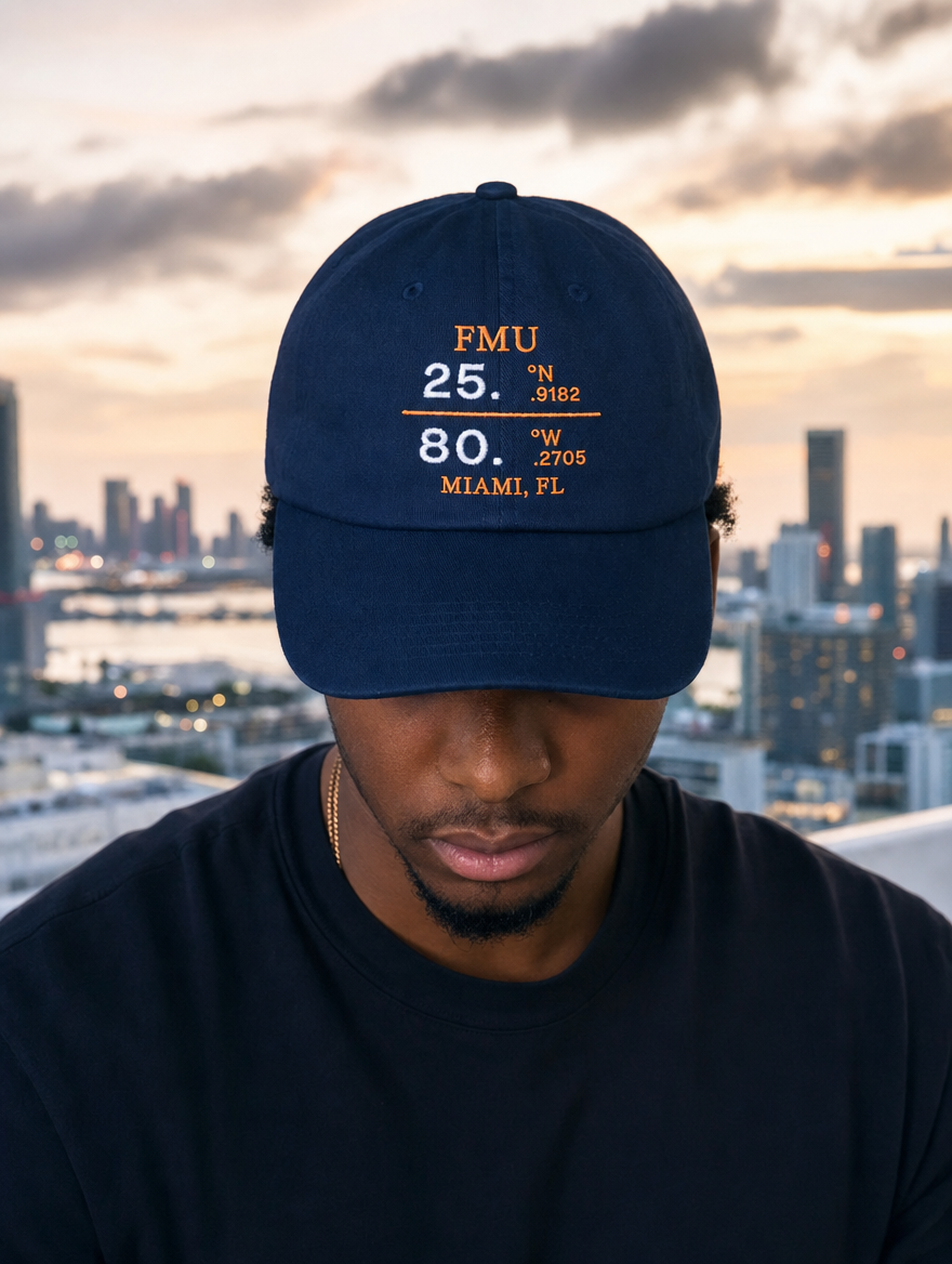 Model in navy FMU Coordinates dad hat, white embroidery, Miami rooftop at dusk