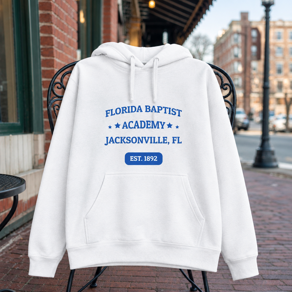Florida Baptist Academy Heritage White hoodie with royal blue lettering and white EST. 1892 badge text, displayed front-facing in a creative garment scene.