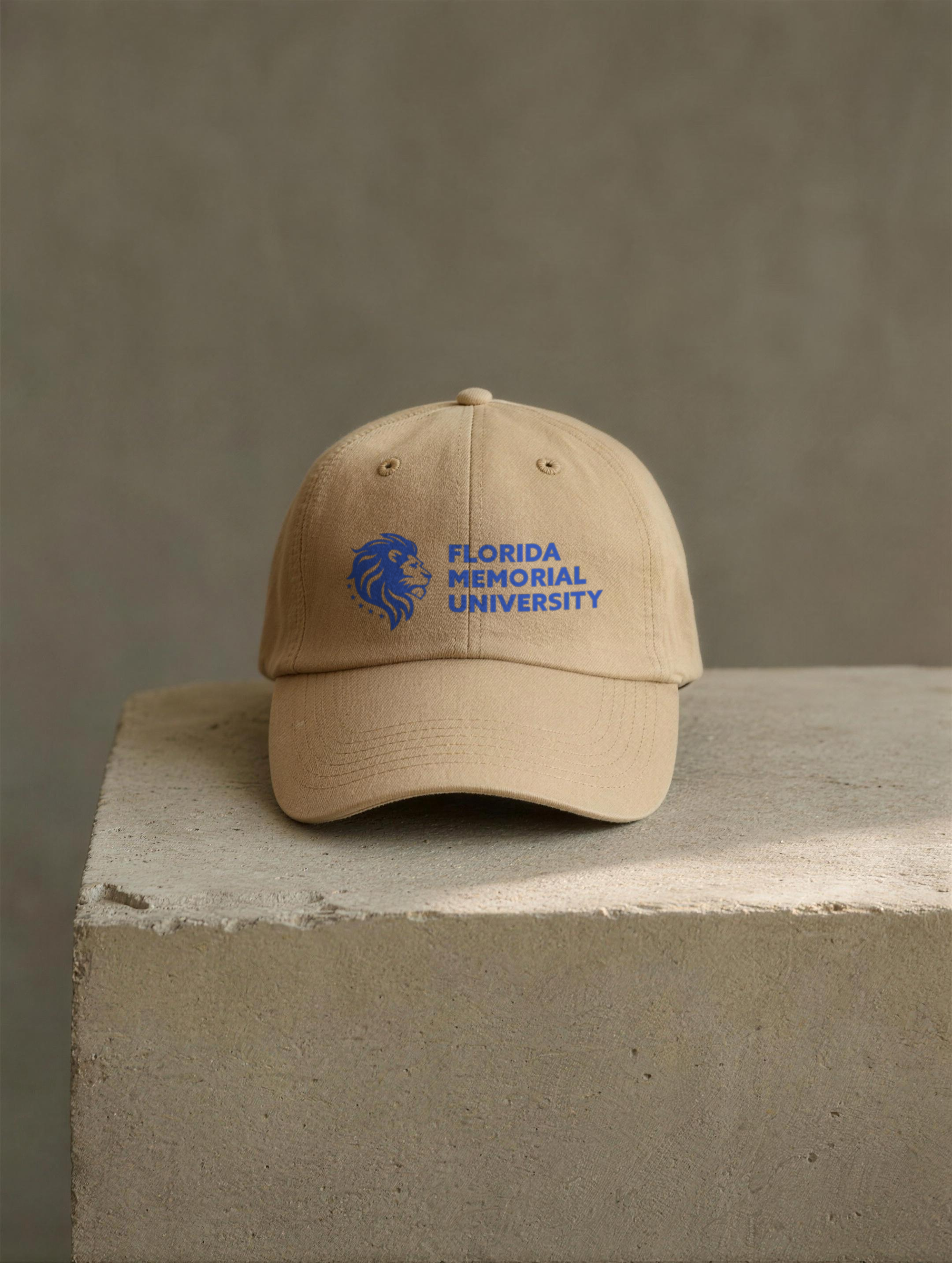 Florida Memorial University Stacked Wordmark dad hat in khaki displayed on a raw concrete plinth